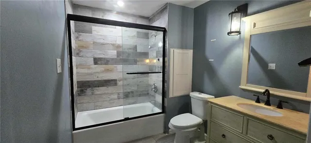 a bathroom with a granite countertop sink toilet and shower