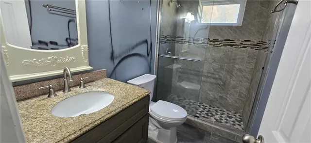 a bathroom with a granite countertop sink toilet and shower