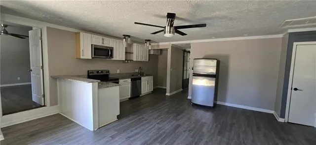 a kitchen with stainless steel appliances granite countertop a refrigerator a stove top oven a sink and dishwasher