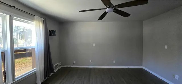 a view of a room with wooden floor and windows