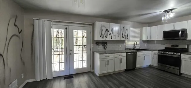 a kitchen with stainless steel appliances granite countertop a stove a sink and a microwave