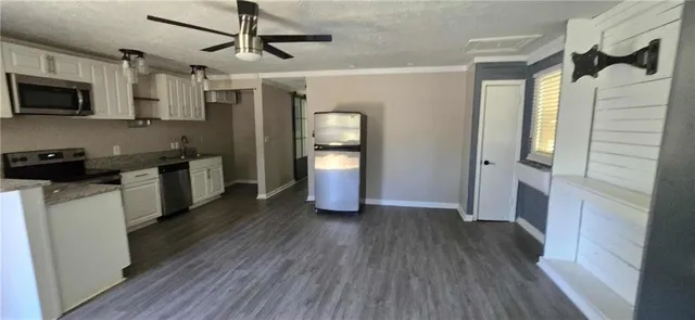 a view of a hallway with wooden floor and cabinets
