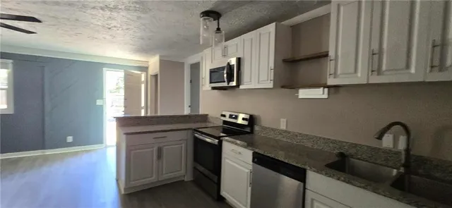 a kitchen with stainless steel appliances granite countertop a sink stove and cabinets