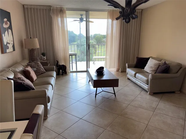 a living room with furniture and a floor to ceiling window