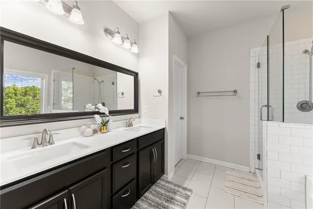 a bathroom with a double vanity sink a mirror and a shower