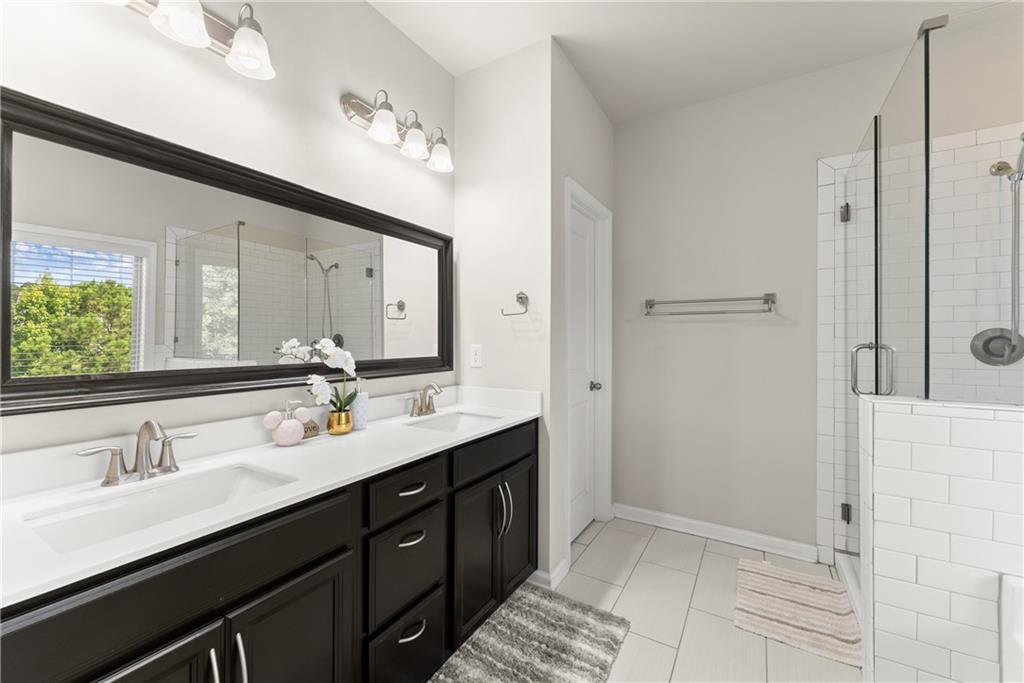 2228 Lakeview Bend Way Buford, GA 30519 - Photo 16 of 36 a bathroom with a double vanity sink a mirror and a shower