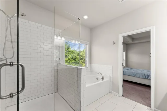 a bathroom with a tub shower and checkered floor