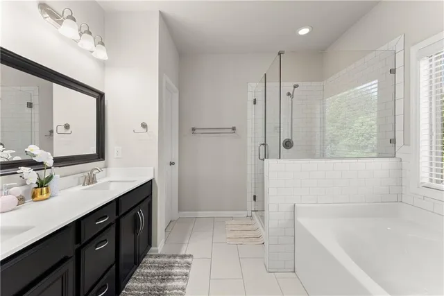 a bathroom with a tub sink and mirror