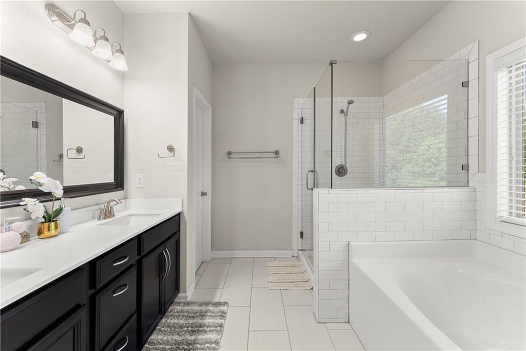 2228 Lakeview Bend Way Buford, GA 30519 - Photo 18 of 36 a bathroom with a tub sink and mirror