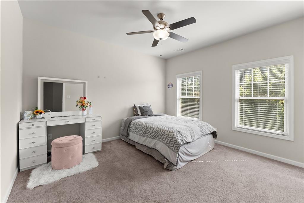 2228 Lakeview Bend Way Buford, GA 30519 - Photo 24 of 36 a spacious bedroom with a large bed and a chandelier