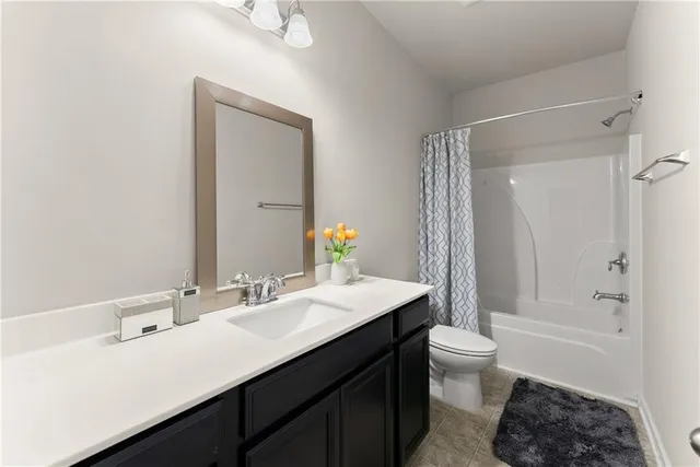 a bathroom with a sink a toilet a mirror and shower