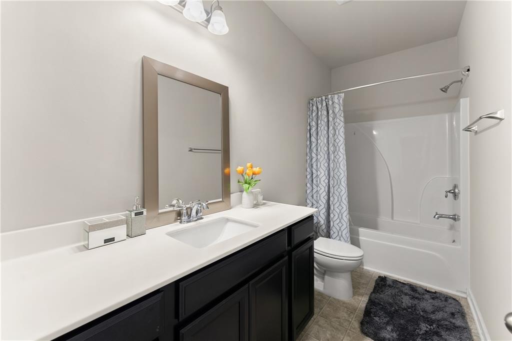 2228 Lakeview Bend Way Buford, GA 30519 - Photo 25 of 36 a bathroom with a sink a toilet a mirror and shower