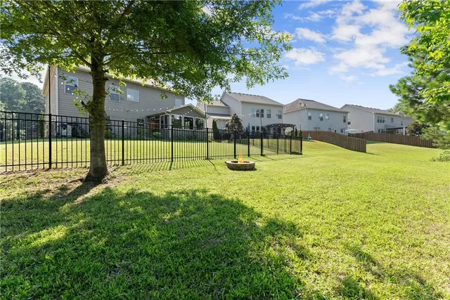 a view of an house with a backyard and a tree
