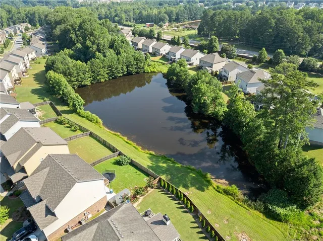 an aerial view of a house with a yard and lake view