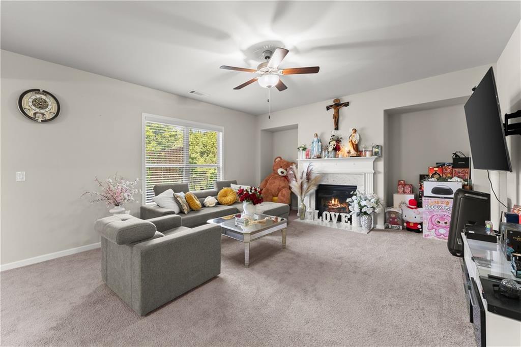 2228 Lakeview Bend Way Buford, GA 30519 - Photo 4 of 36 a living room with furniture a fireplace and a flat screen tv