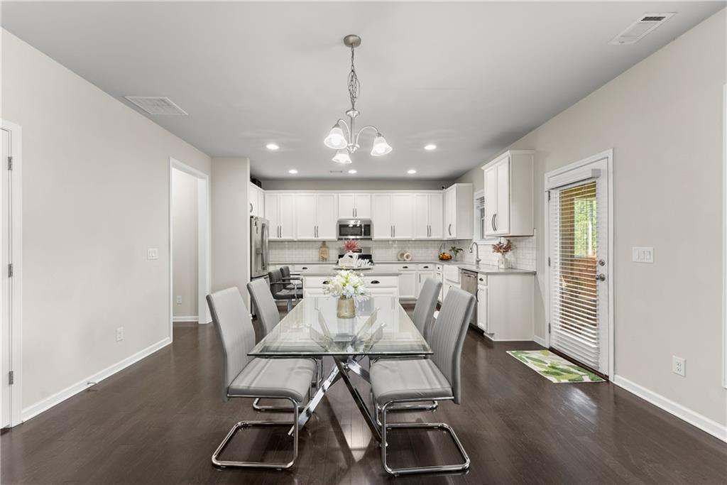 2228 Lakeview Bend Way Buford, GA 30519 - Photo 6 of 36 a view of a dining room with furniture and wooden floor