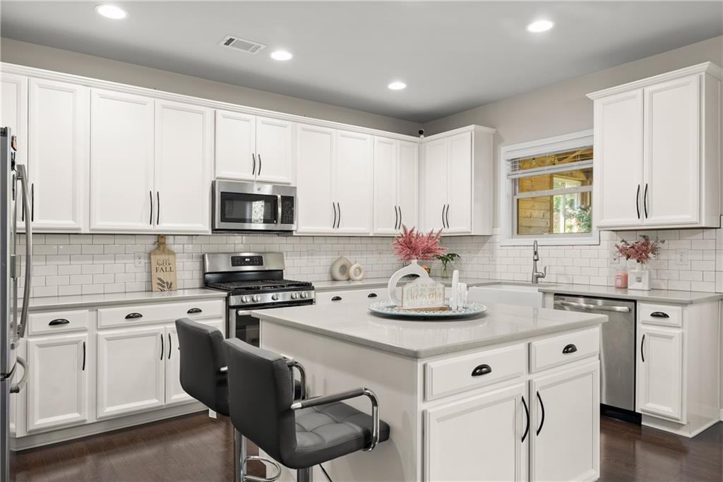 2228 Lakeview Bend Way Buford, GA 30519 - Photo 7 of 36 a kitchen with white cabinets and appliances