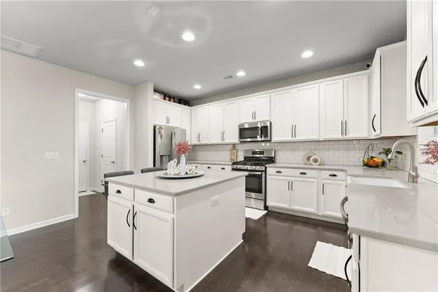a kitchen with appliances a sink and cabinets