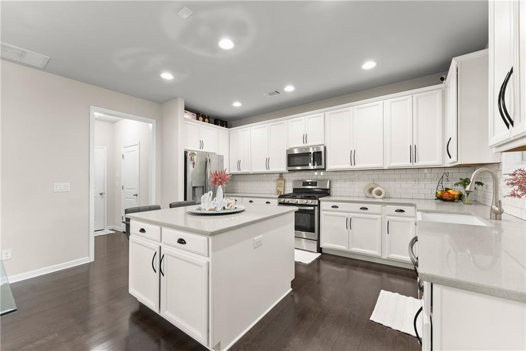 2228 Lakeview Bend Way Buford, GA 30519 - Photo 8 of 36 a kitchen with appliances a sink and cabinets