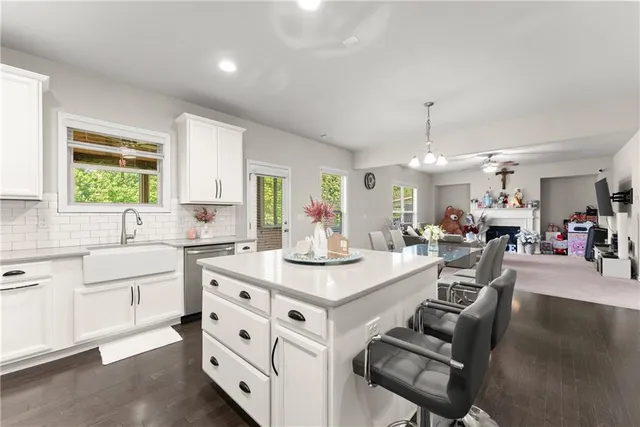 a kitchen with stainless steel appliances kitchen island granite countertop a sink cabinets and wooden floor