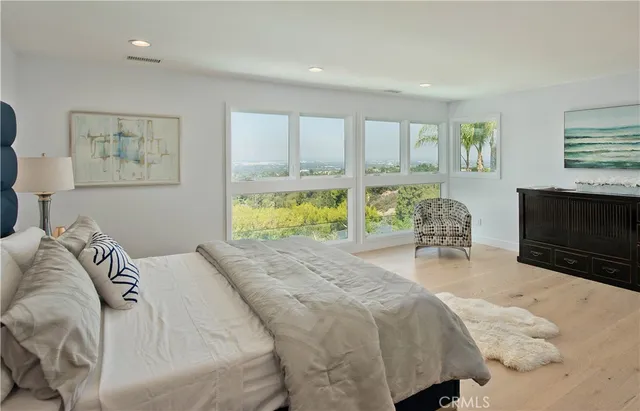 a spacious bedroom with a bed a couch and large window