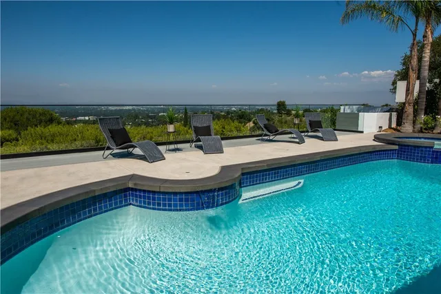 a view of a house with swimming pool and sitting area