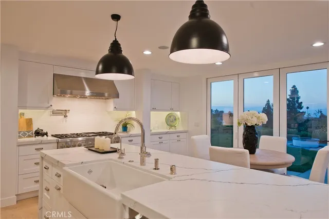 a kitchen with a stove a chandelier and a dining table