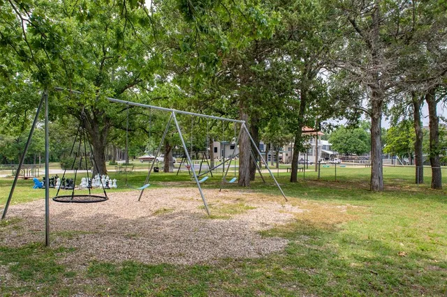 a patio with a table and chairs under an umbrella with a barbeque