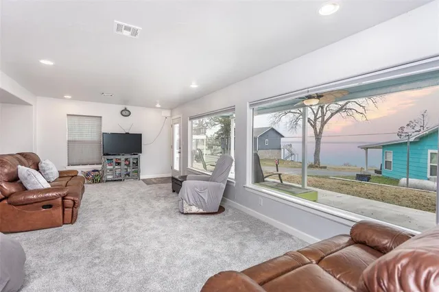 a kitchen with stainless steel appliances granite countertop a stove a sink a refrigerator and white cabinets with wooden floor