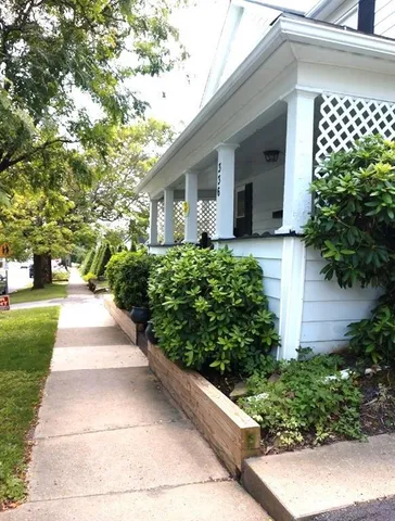 a front view of a house with a yard and potted plants