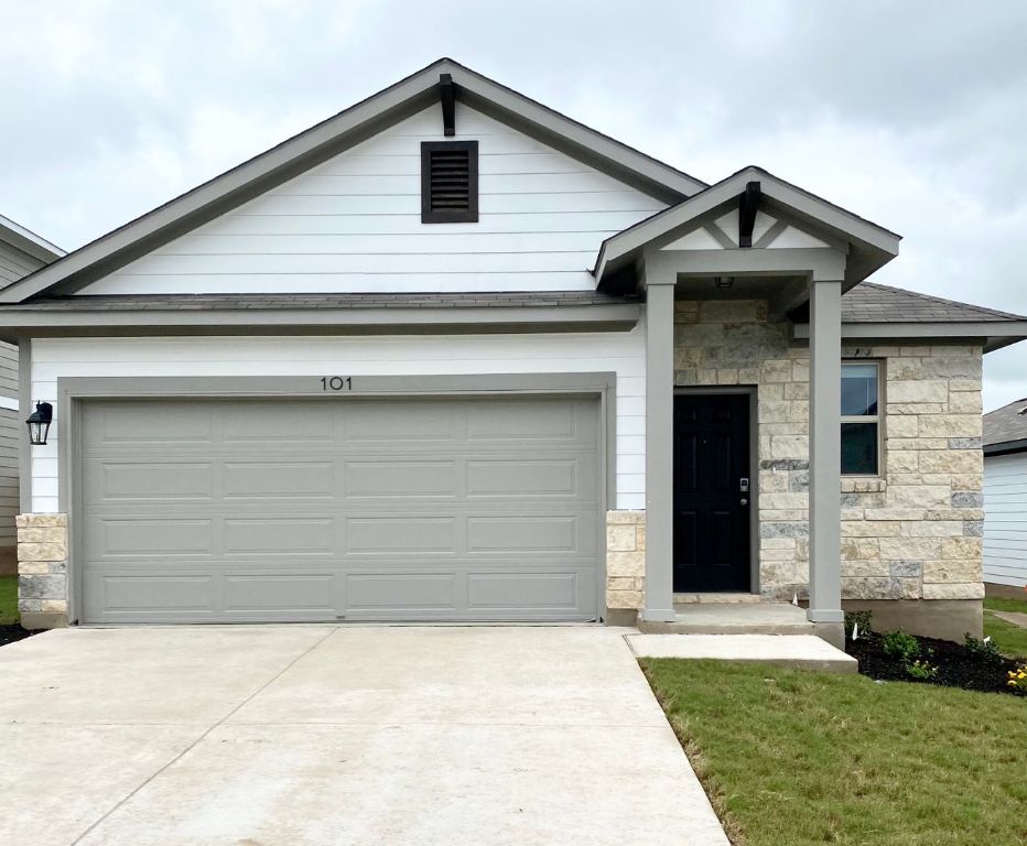 103 Wild Wind Cove Jarrell, TX 76537 - Photo 1 of 11 a front view of a house with a yard and garage