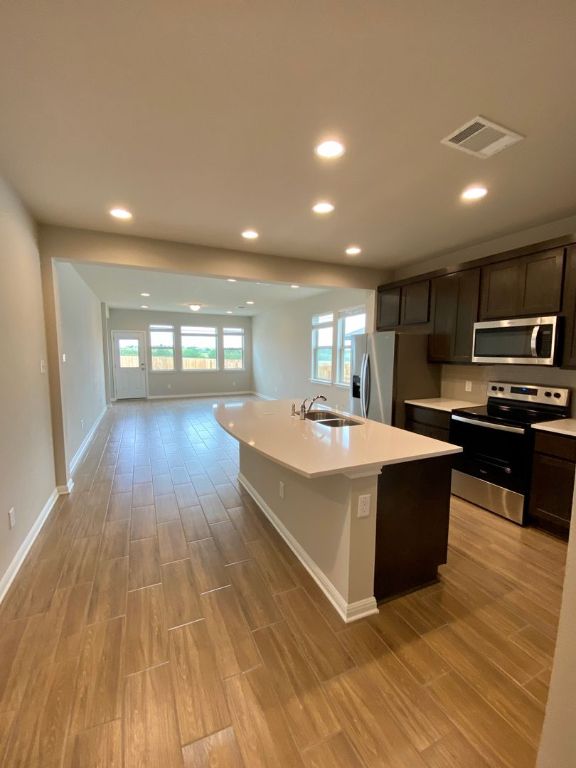103 Wild Wind Cove Jarrell, TX 76537 - Photo 10 of 11 a large kitchen with stainless steel appliances granite countertop a large counter top and wooden floors