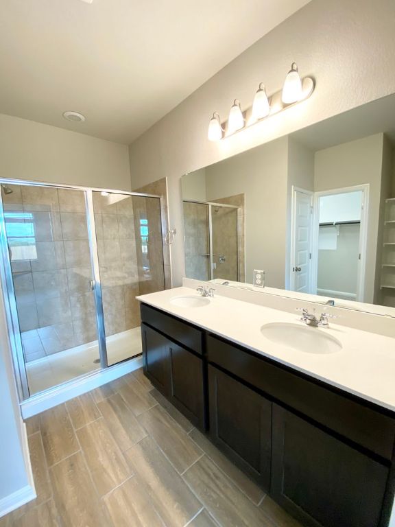 103 Wild Wind Cove Jarrell, TX 76537 - Photo 6 of 11 a spacious bathroom with a double vanity sink a large mirror and a shower