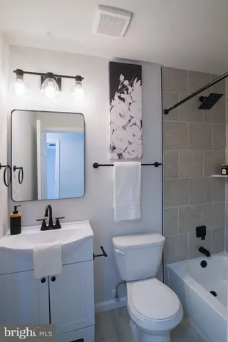 a bathroom with a sink mirror toilet and bathtub