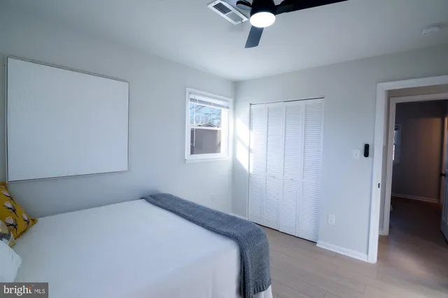 a bedroom with a bed and a chandelier fan