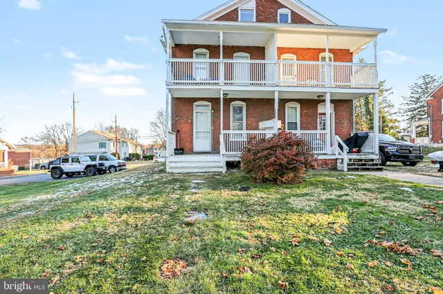 a view of a house with a yard and lawn chairs