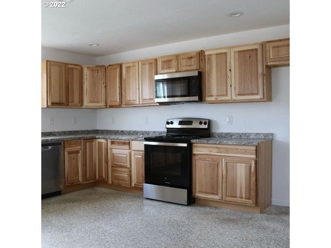 409 West Ridgeway Avenue Hermiston, OR 97838 - Photo 15 of 16 a kitchen with stainless steel appliances granite countertop a stove top oven a sink and dishwasher