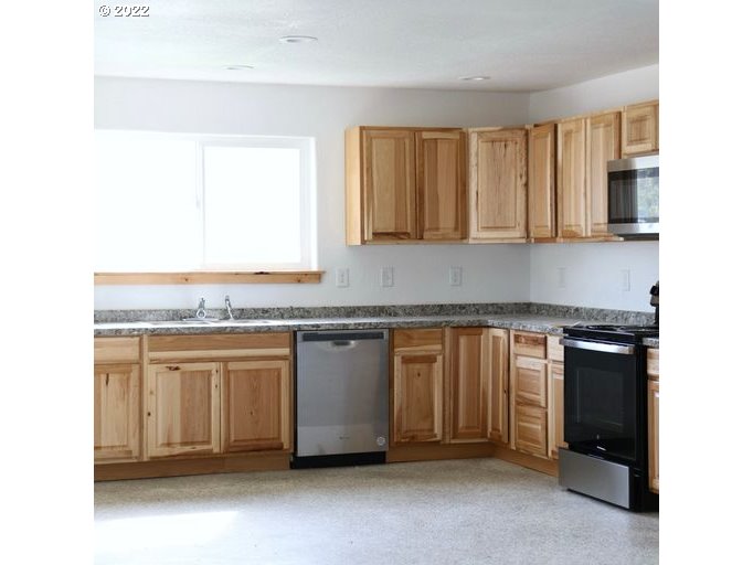 409 West Ridgeway Avenue Hermiston, OR 97838 - Photo 16 of 16 a kitchen with granite countertop a sink and a stove
