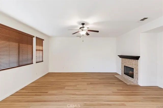 a view of an empty room with a fireplace and a window