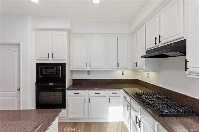 a kitchen with white cabinets and appliances