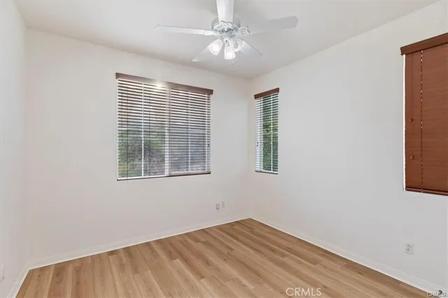 an empty room with a window and a ceiling fan