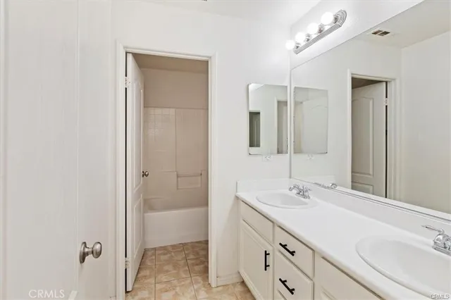 a bathroom with a double vanity sink a mirror and a shower