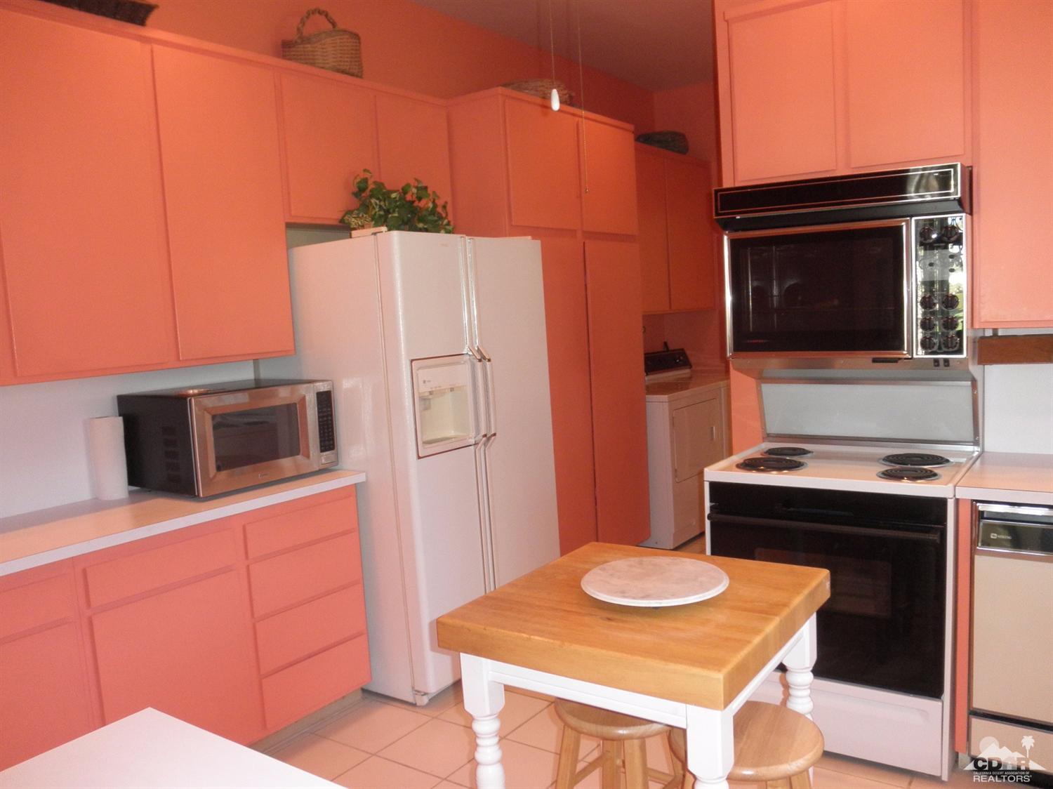 47432 Rabat Drive Palm Desert, CA 92260 - Photo 11 of 21 a kitchen with stainless steel appliances kitchen island granite countertop a stove a microwave and a refrigerator