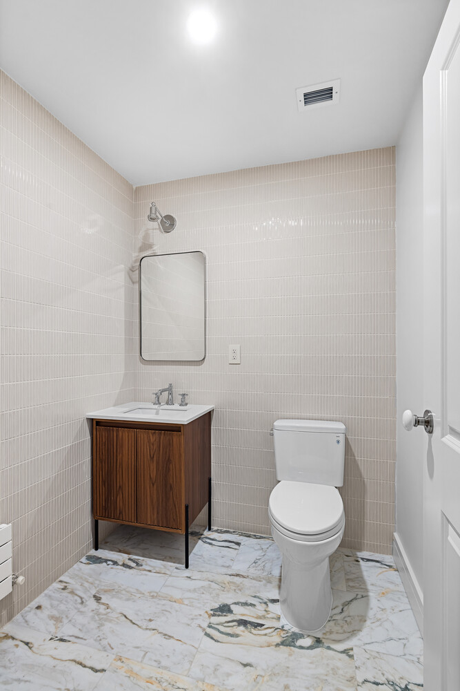 232 Adelphi Street, Unit 4 Brooklyn, NY 11205 - Photo 14 of 15 a bathroom with a toilet a sink and mirror