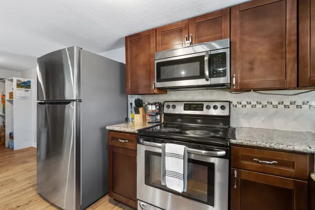 a kitchen with stainless steel appliances granite countertop a refrigerator stove and microwave