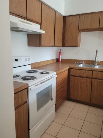 a kitchen with a stove sink and cabinets