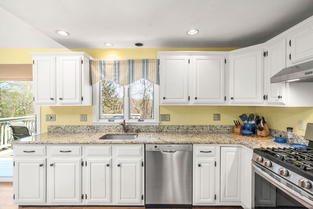 9 Davis Road Hudson, MA 01749 - Photo 14 of 32 a kitchen with granite countertop a sink a stove a counter space and cabinets