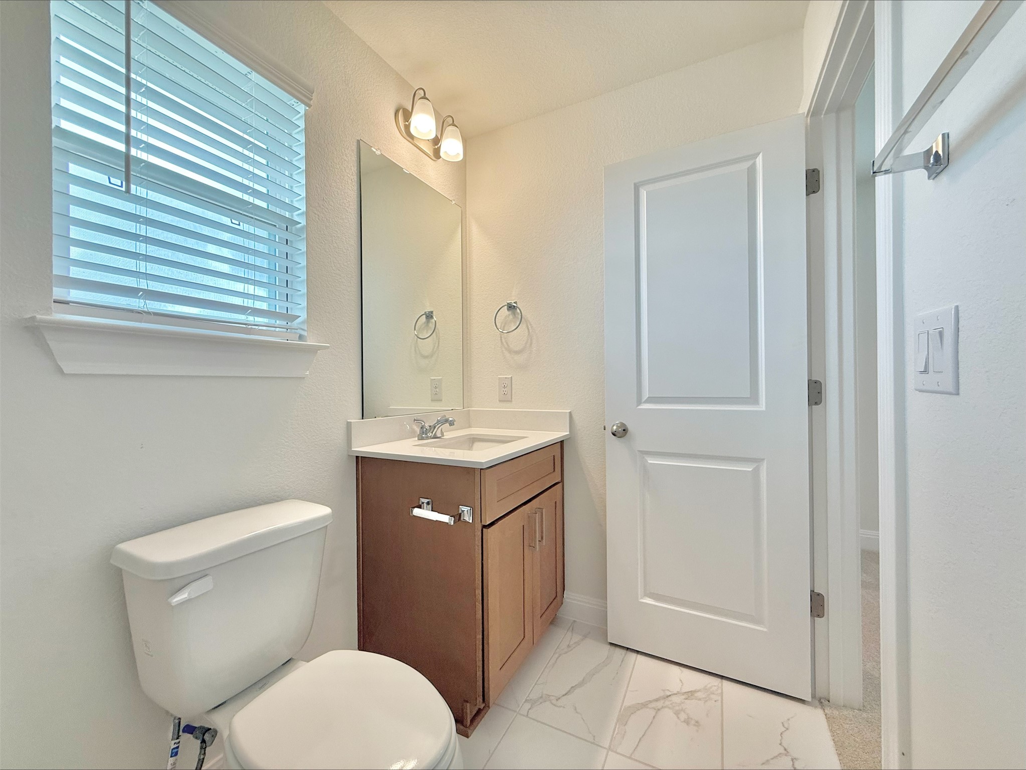 405 Young Street Buda, TX 78610 - Photo 18 of 25 a bathroom with a toilet a sink and mirror