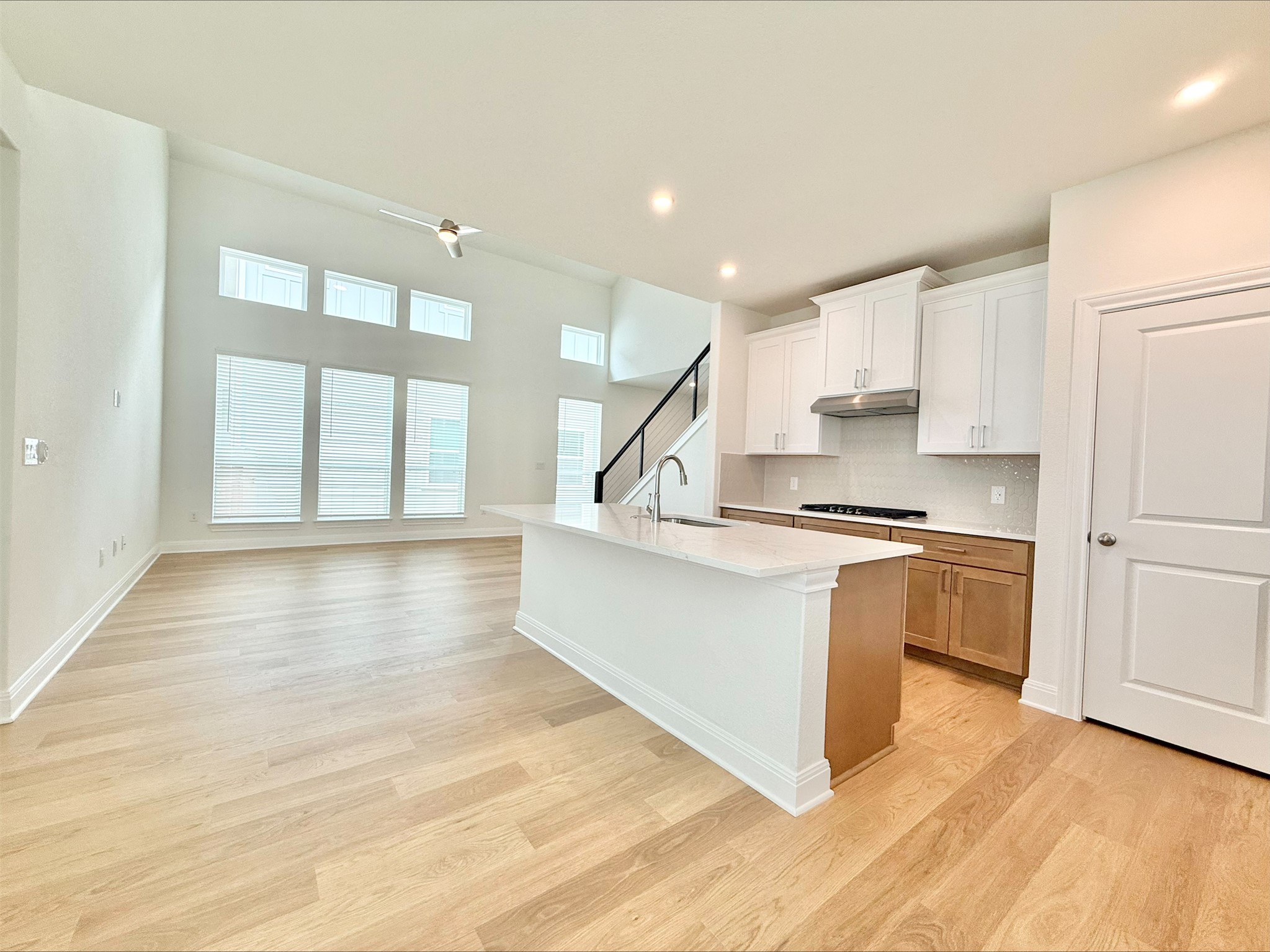 405 Young Street Buda, TX 78610 - Photo 4 of 25 a large white kitchen with wooden floors and a fireplace