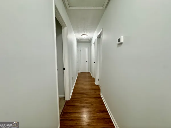 a view of a hallway with wooden floor
